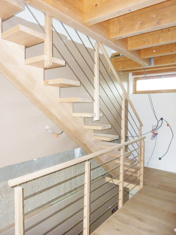 Escalier à limon central en bois massif réalisé par la Menuiserie Hortail.